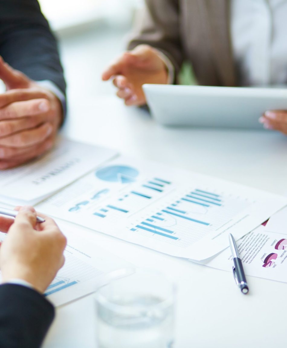 Image of business documents, pen and glasses on workplace during meeting of partners